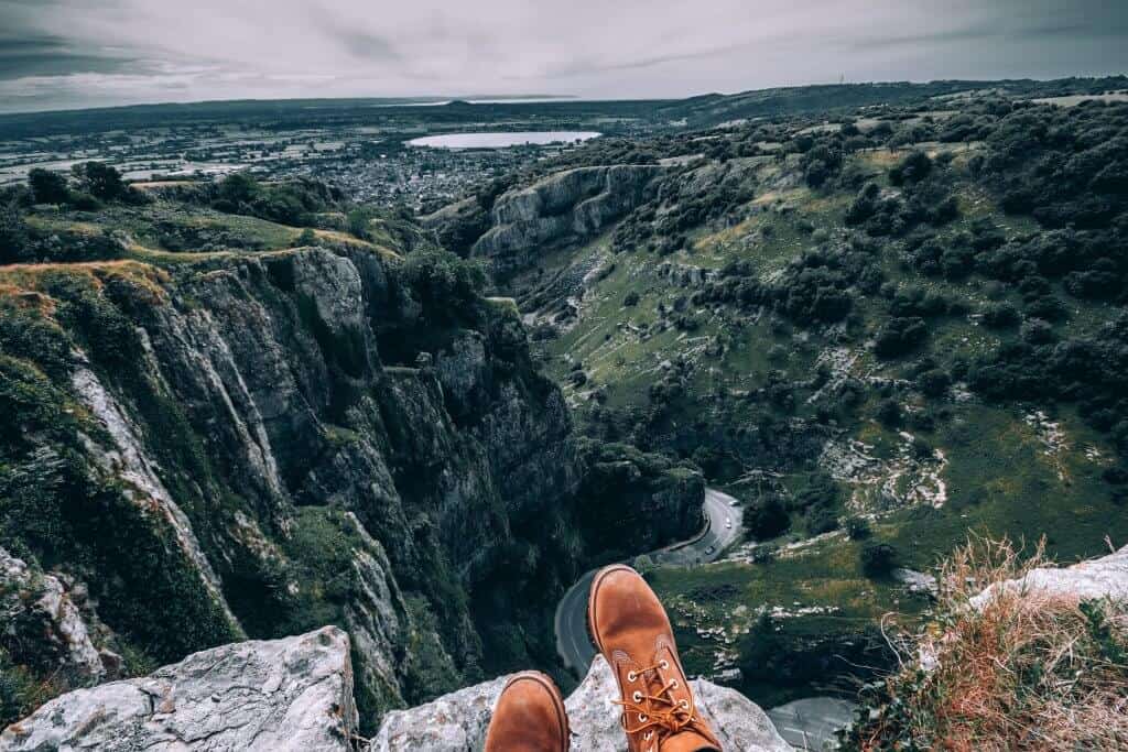Cheddar Gorge as seen from above - cliff faces with bushes and a road below