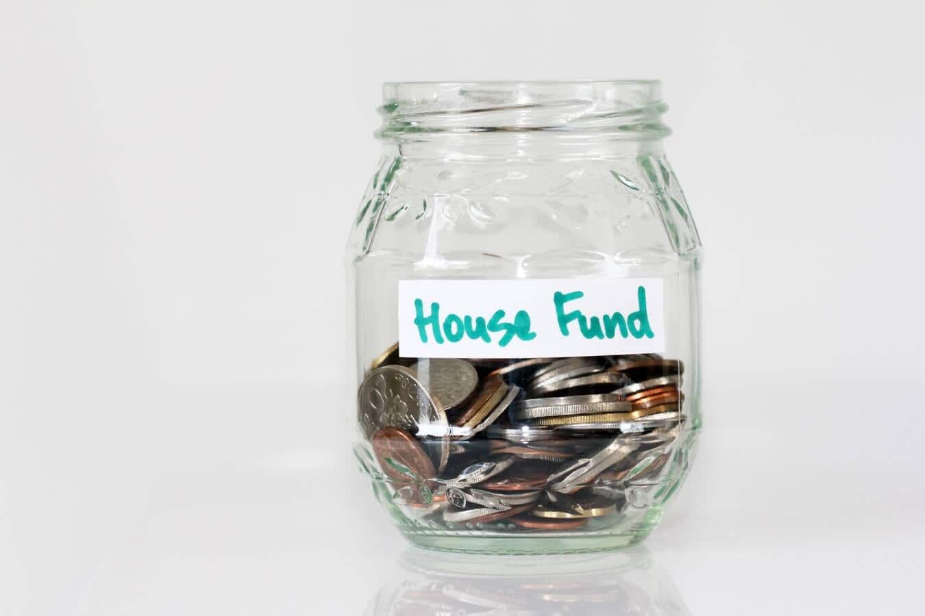 A jar of money, with a label on it saying "house fund"